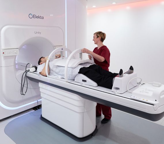 A doctor helping a patient lying on an MRI machine
